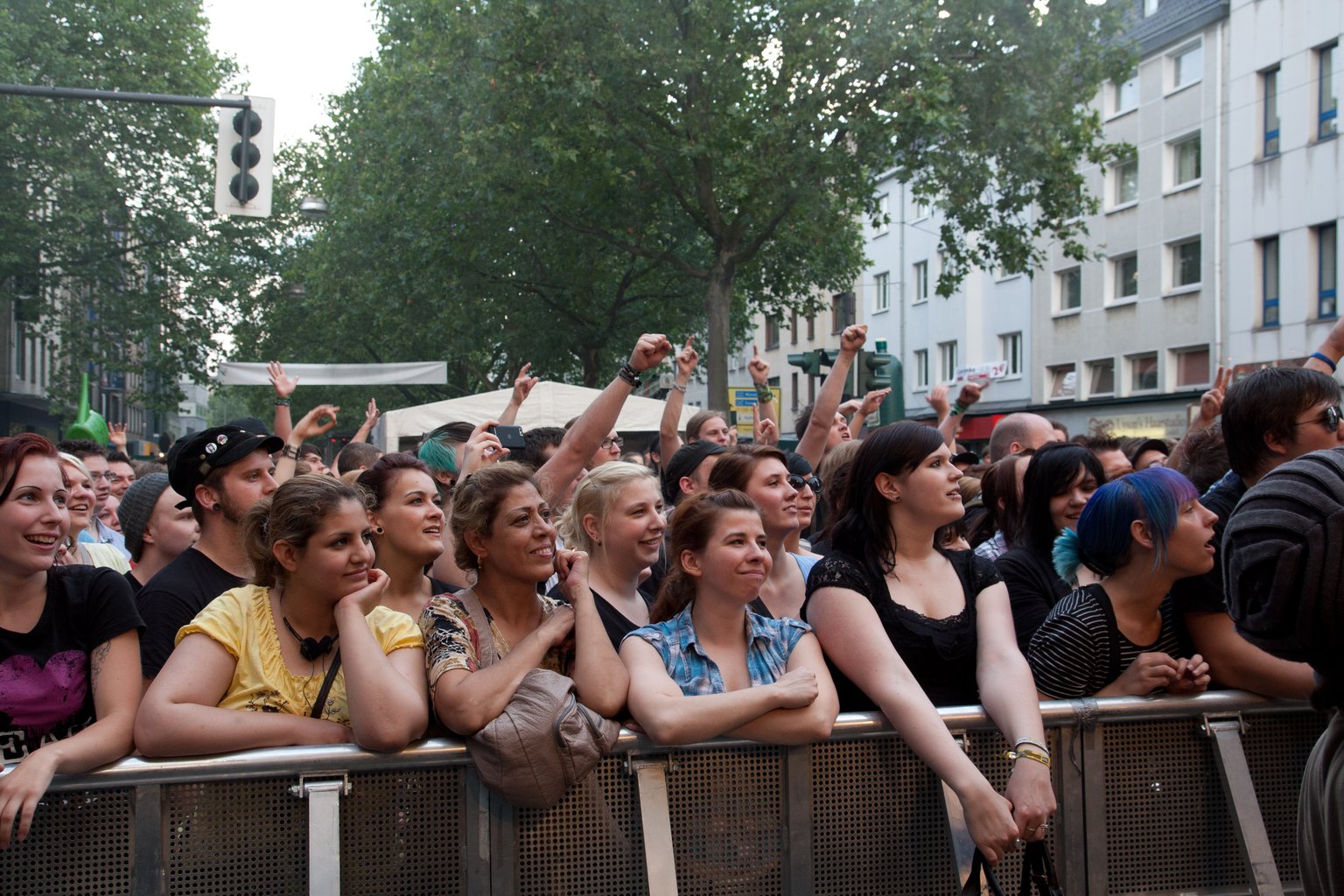 Young mostly female crowd standing behind the barrier, lots of dreamy faces